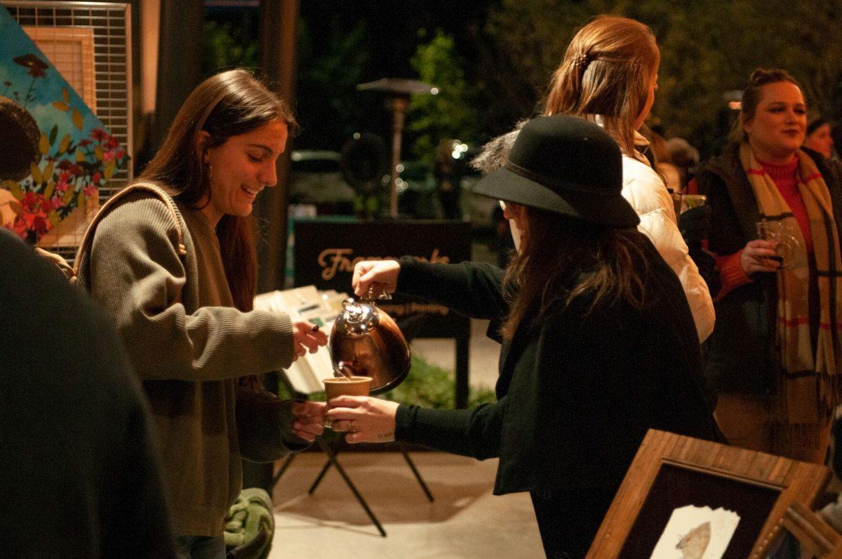 A vendor pours a customer a drink on Friday, Nov. 18, 2022, at Mid City Merchant's White Light Night on Government Street in Baton Rouge, La.