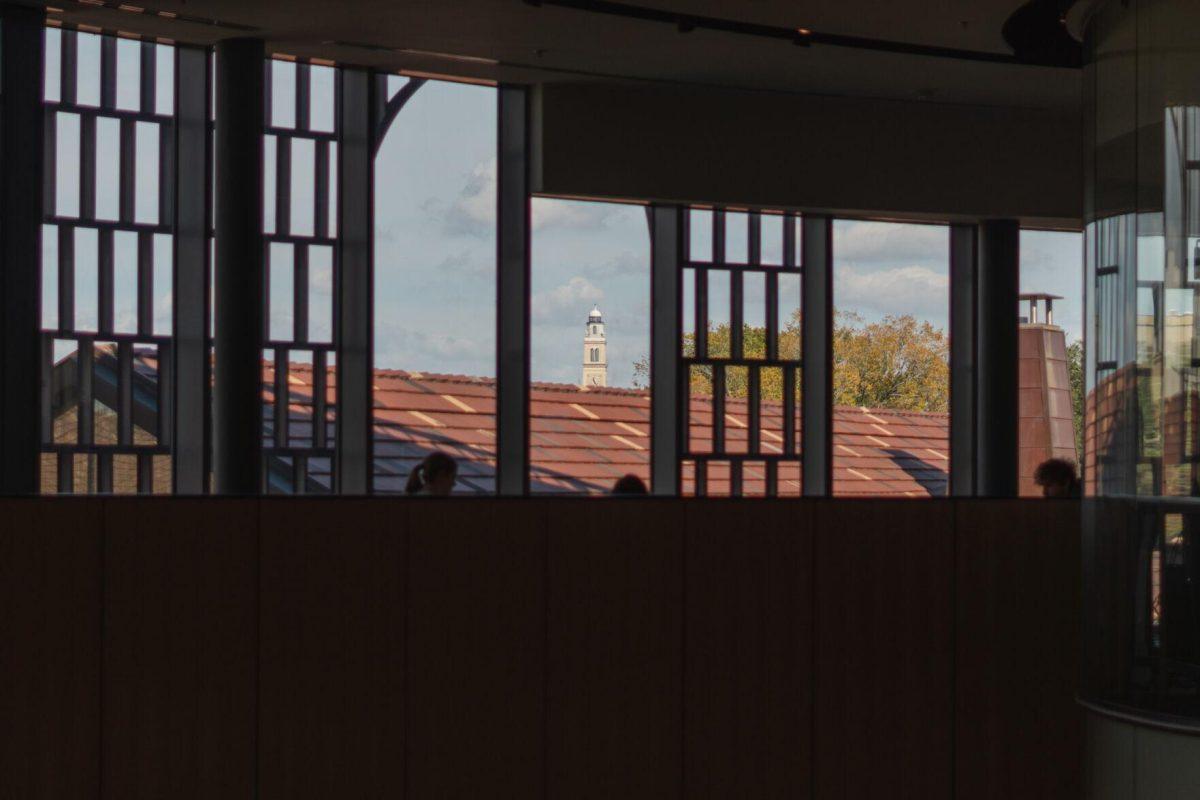 Memorial Tower stands in the distance on Monday, Oct. 31, 2022, as students study inside the Business Education Complex on LSU's campus.