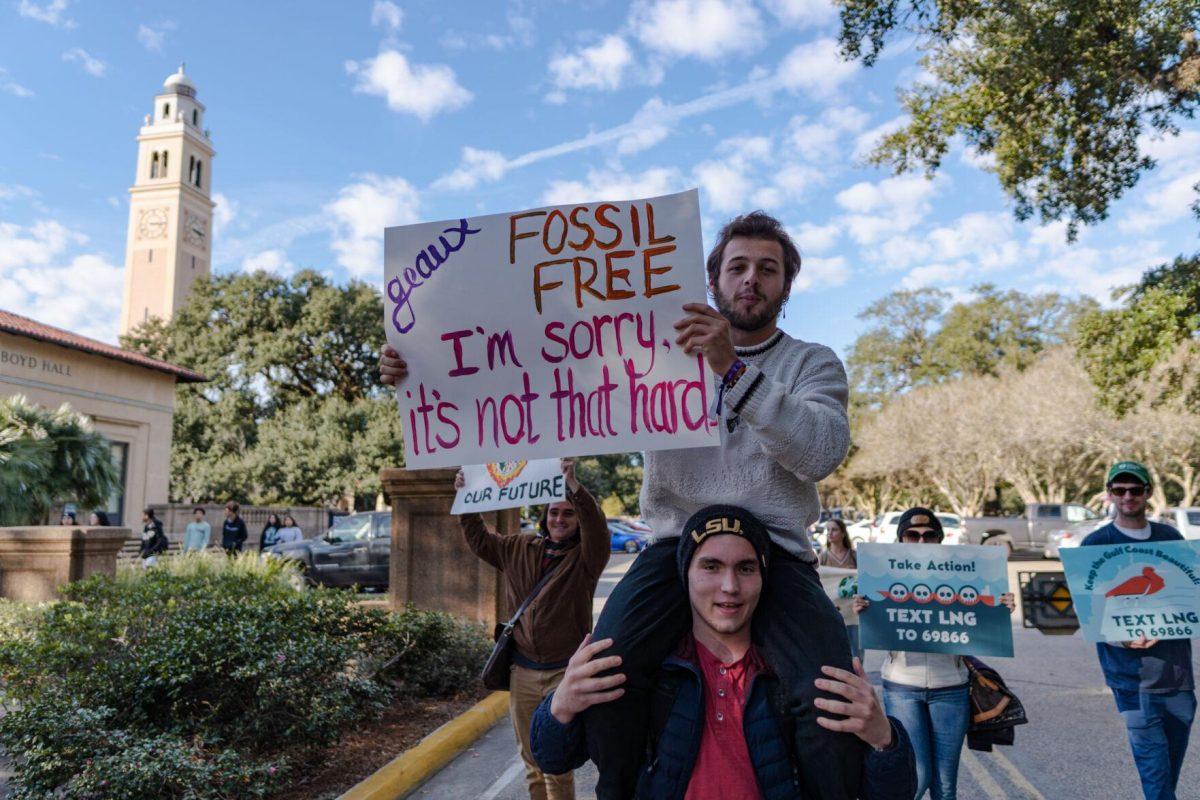 March attendees carry signs and chant on Friday, Nov. 18, 2022, as they march down Tower Drive in Baton Rouge, La.