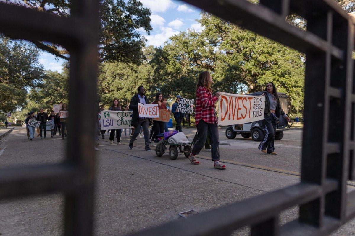 Protesters march and chant on Friday, Nov. 18, 2022, as they walk to the LSU Foundation building in Baton Rouge, La.