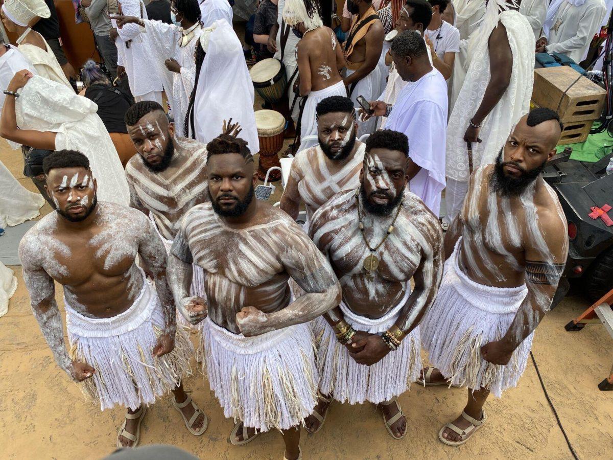 Floyd Anthony Johns Jr. stands with other crew members in costume and makeup on the set of "Black Panther: Wakanda Forever."