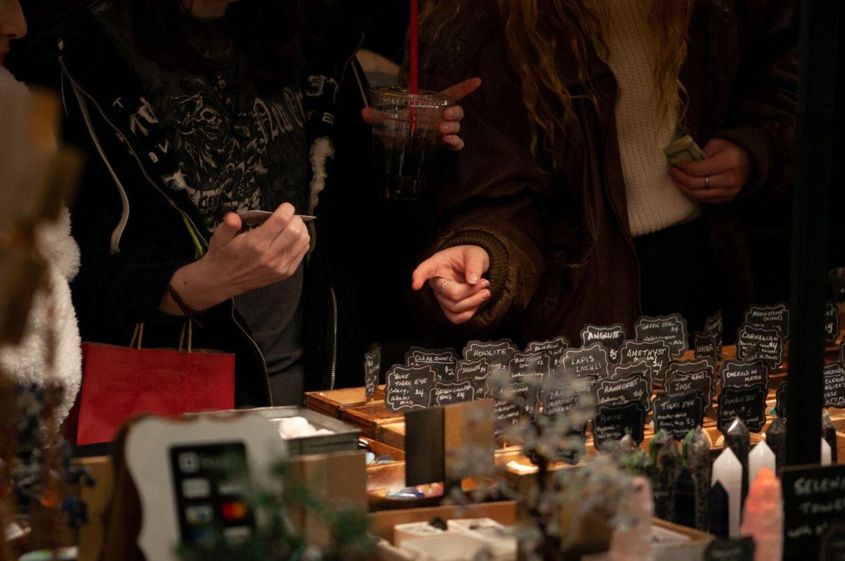 Guests point and examine products on Friday, Nov. 18, 2022, at Mid City Merchant's White Light Night on Government Street in Baton Rouge, La.