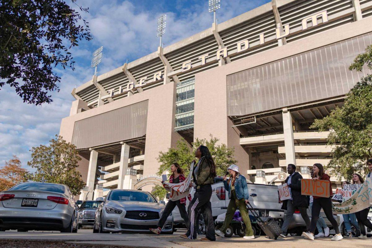 Protesters march past Tiger Stadium on Friday, Nov. 18, 2022, on South Stadium Drive in Baton Rouge, La.