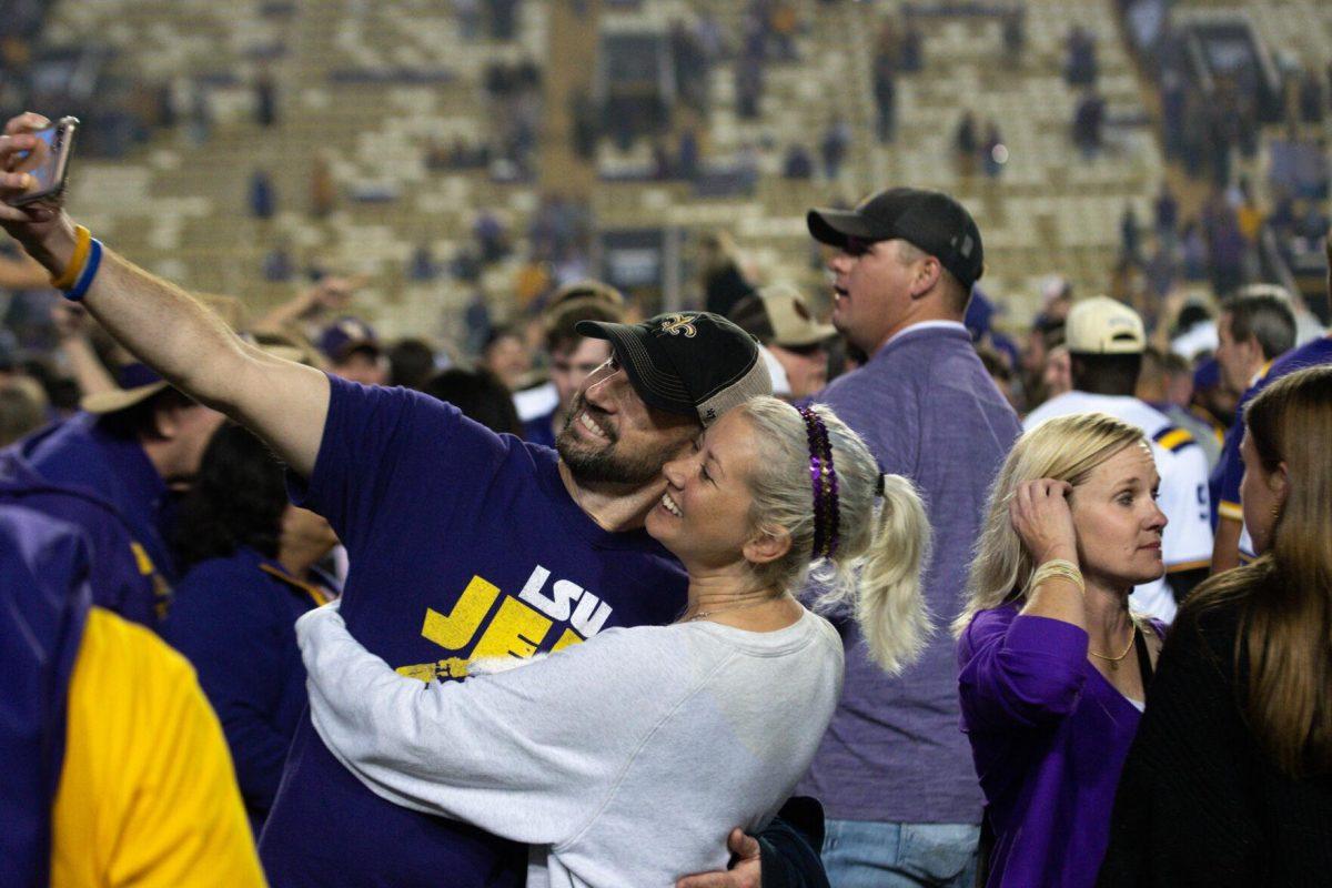 A couple takes a selfie after storming the field on Saturday, Nov. 5, 2022, during LSU&#8217;s 32-31 victory over Alabama in Tiger Stadium in Baton Rouge, La.