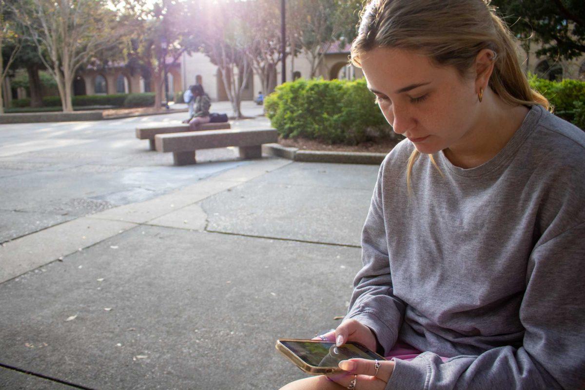 LSU junior Madison Lawrence uses her phone on Wednesday, Nov. 9, 2022, in the Quad on LSU's campus.