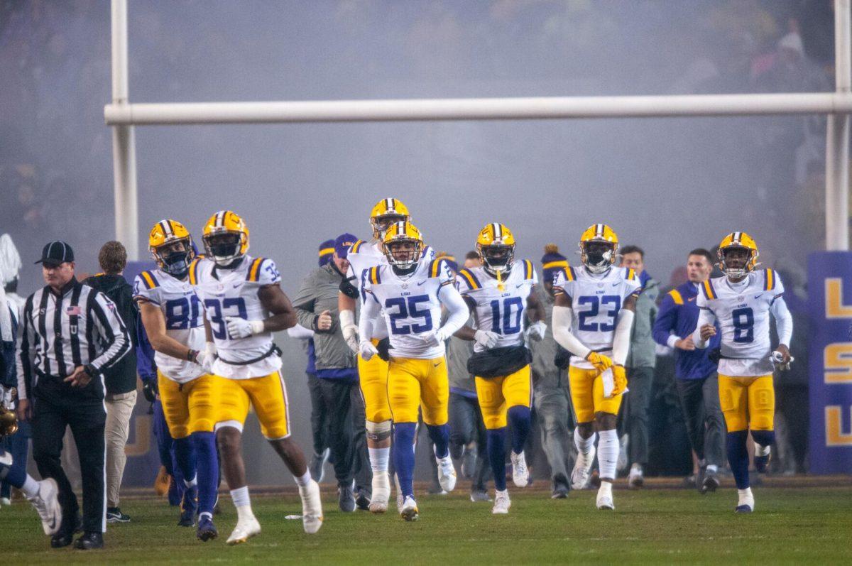 The LSU football team runs onto the field through the smoke during pregame on Saturday, Nov. 19, 2022, inside Tiger Stadium in Baton Rouge, La.