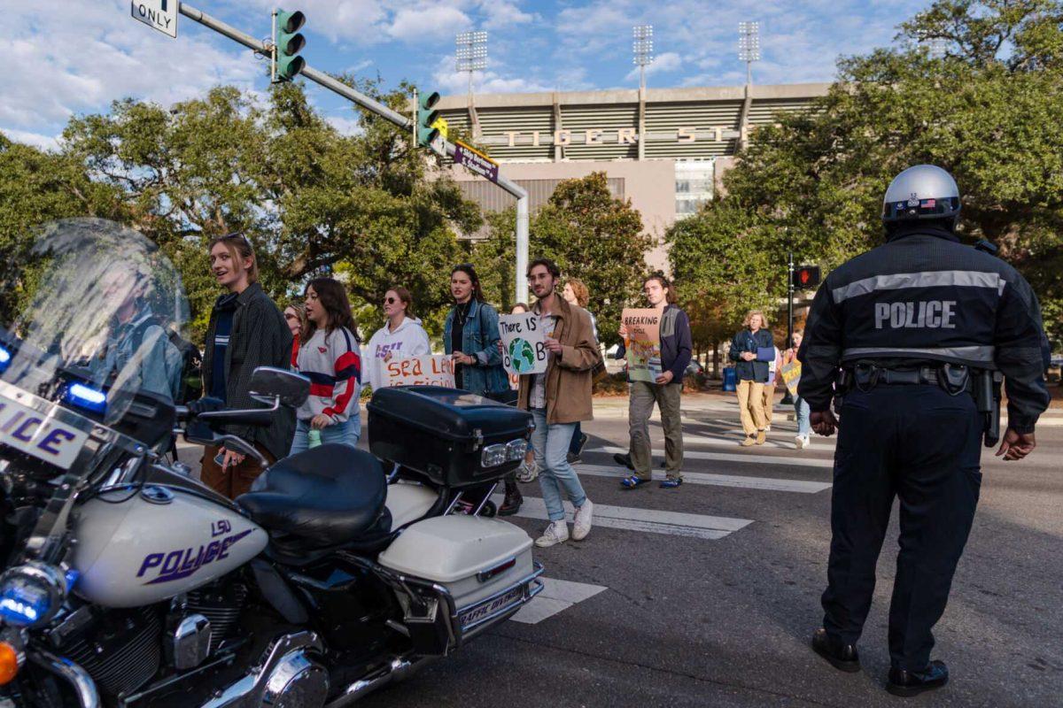 Police assist as rally-goers cross Nicholson Drive on Friday, Nov. 18, 2022, during a climate march in Baton Rouge, La.