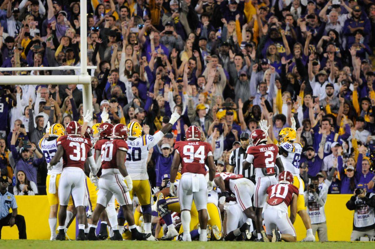 Football players cheer with the crowd after a call on Saturday, Nov. 5, 2022, during LSU&#8217;s 32-31 victory over Alabama in Tiger Stadium in Baton Rouge, La.