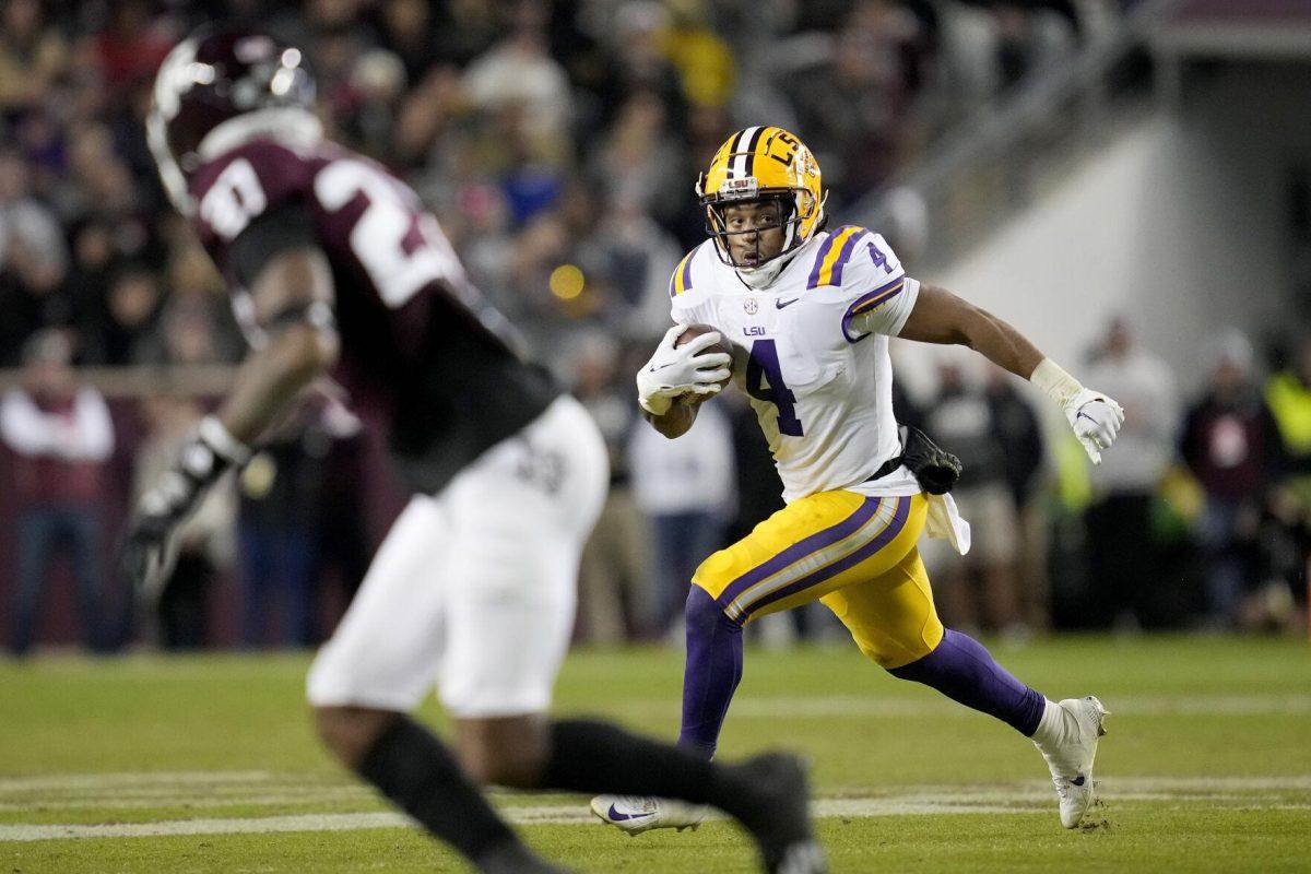 LSU running back John Emery Jr. (4) carries as Texas A&amp;M defensive back Antonio Johnson (27) defends during the second quarter of an NCAA college football game Saturday, Nov. 26, 2022, in College Station, Texas. (AP Photo/Sam Craft)