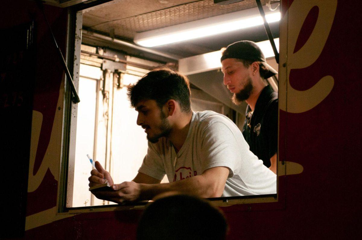 An employee takes orders from the Curbside Burgers food truck on Friday, Nov. 18, 2022, at Mid City Merchant's White Light Night on Government Street in Baton Rouge, La.