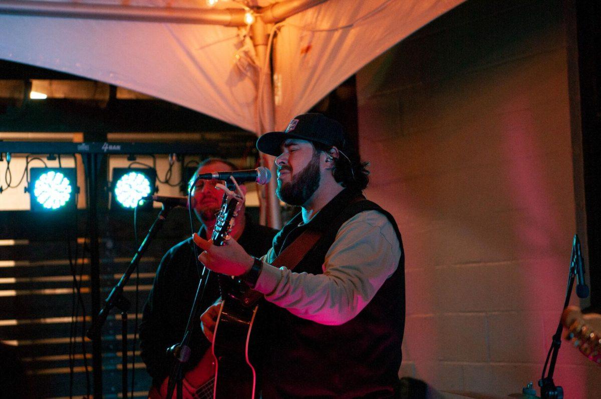 The singer of a country music band performs on Friday, Nov. 18, 2022, at Mid City Merchant's White Light Night on Government Street in Baton Rouge, La.