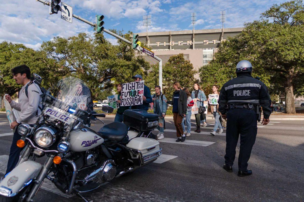 Police assist as rally-goers cross Nicholson Drive on Friday, Nov. 18, 2022, during a climate march in Baton Rouge, La.