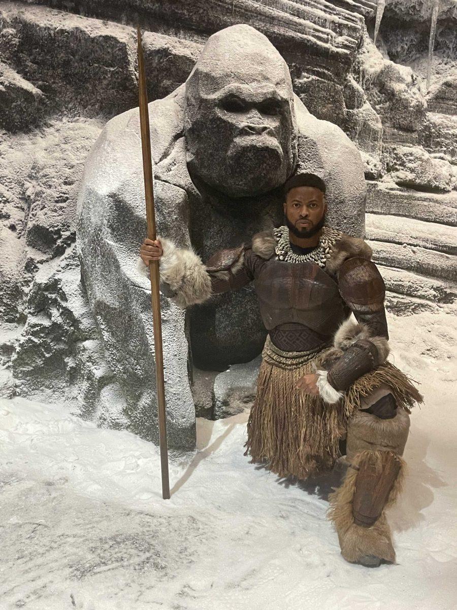 Floyd Anthony Johns Jr., an LSU alumnus, kneels, holding his Jabari Warrior spear while filming "Black Panther: Wakanda Forever."