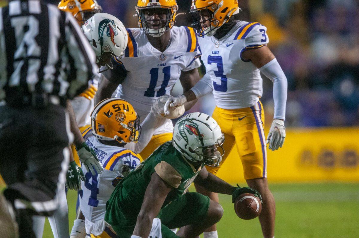 LSU football senior safety Greg Brooks Jr. (3) and football senior defensive end Ali Gaye (11) help their fellow teammate up on Saturday, Nov. 19, 2022, during the LSU vs. UAB game in Baton Rouge, La.