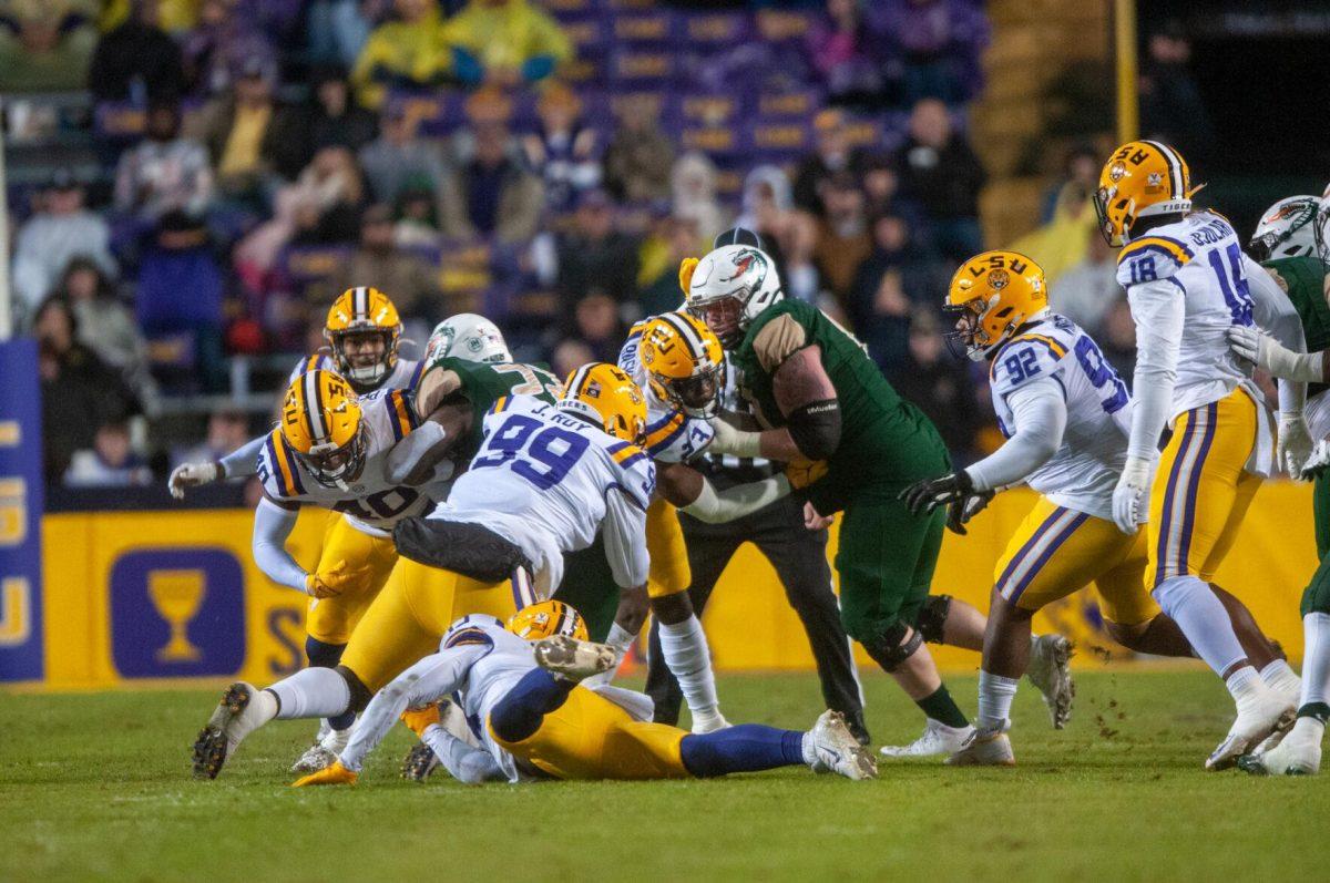 LSU football junior defensive tackle Jaquelin Roy (99) tackles among other LSU football players on Saturday, Nov. 19, 2022, during the LSU vs. UAB game in Baton Rouge, La.