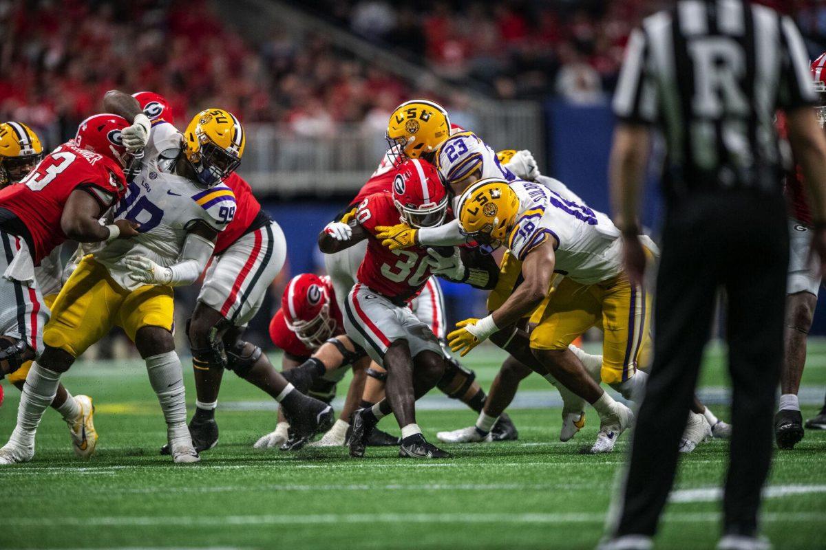Georgia football junior tight end Daijun Edwards pushes off LSU defenders Saturday, Dec. 3, 2022, during LSU's 30-50 defeat to Georgia at the Southeastern Conference Championship at the Mercedes-Benz Stadium in Atlanta, Georgia.