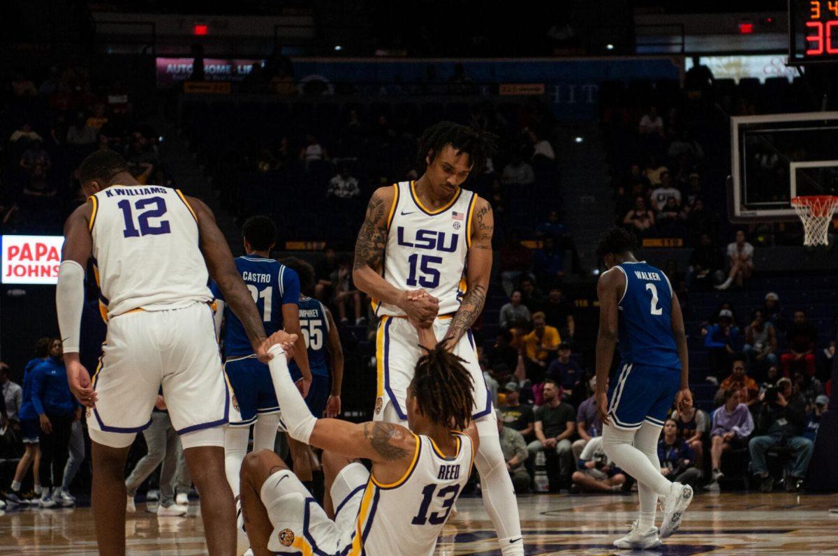 LSU men&#8217;s basketball KJ Williams (12) and Tyrell Ward (15) help up Jalen Reed (13) during LSU&#8217;s 63-59 win against UT Arlington on Friday, Dec. 2, 2022, in the Pete Maravich Assembly Center on N. Stadium Drive in Baton Rouge, La.