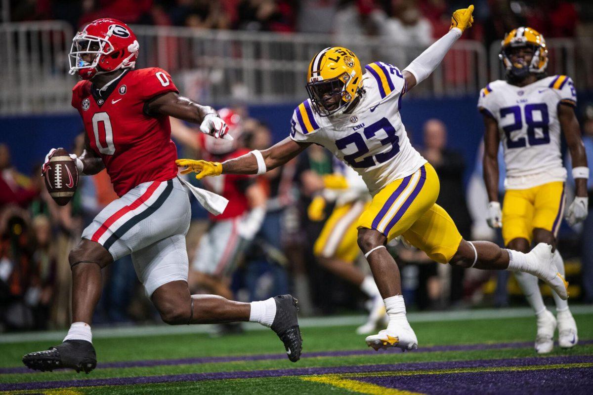 Georgia football junior tight-end Darnell Washington (0) makes a touchdown while LSU fifth-year senior linebacker Micah Baskerville (23) tries to stop him Saturday, Dec. 3, 2022, during LSU's 30-50 defeat to Georgia at the Southeastern Conference Championship at the Mercedes-Benz Stadium in Atlanta, Georgia.