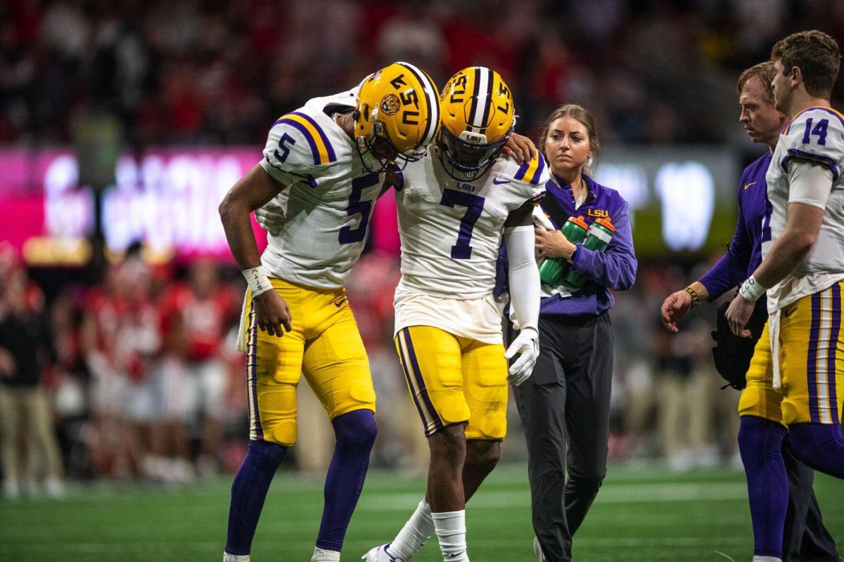 LSU football junior wide receiver Kayshon Boutte (7) helps junior quarterback Jayden Daniels (5) off the field after an injury Saturday, Dec. 3, 2022, during LSU's 30-50 defeat to Georgia at the Southeastern Conference Championship at the Mercedes-Benz Stadium in Atlanta, Georgia.