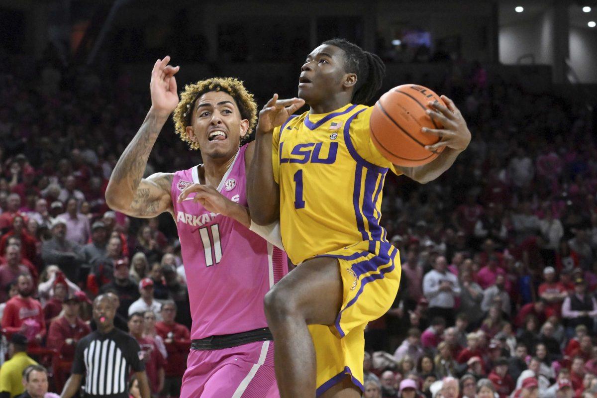 LSU guard Cam Hayes (1) tries to drive past Arkansas forward Jalen Graham (11) during the first half of an NCAA college basketball game Tuesday, Jan. 24, 2023, in Fayetteville, Ark. (AP Photo/Michael Woods)