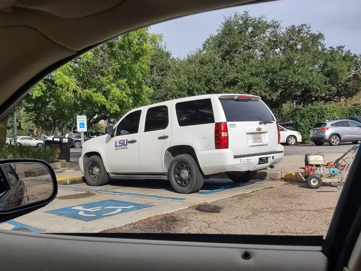 An LSU Facility Services vehicle parks in a handicapped parking spot in Baton Rouge, La.