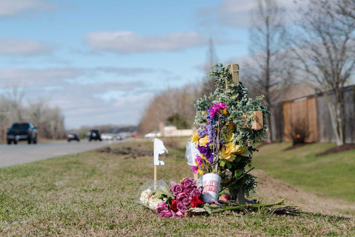 Flowers and a cross sit on Wednesday, Jan. 25, 2023, near where Madison Brooks was struck by a vehicle on Burbank Drive in Baton Rouge, La.