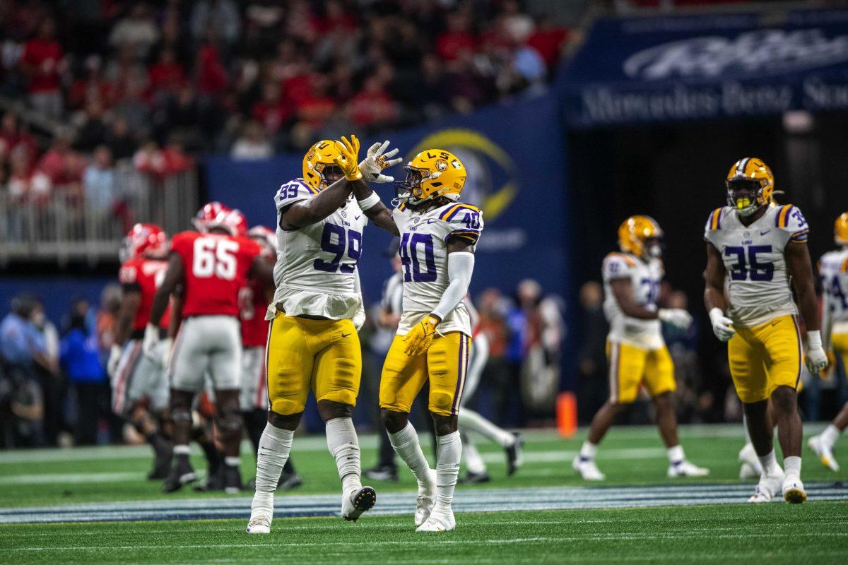 LSU football freshman linebacker Harold Perkins Jr. (40) celebrates with junior defensive tackle Jaquelin Roy (99) after recovering a fumble Saturday, Dec. 3, 2022, during LSU's 30-50 defeat to Georgia at the Southeastern Conference Championship at the Mercedes-Benz Stadium in Atlanta, Georgia.