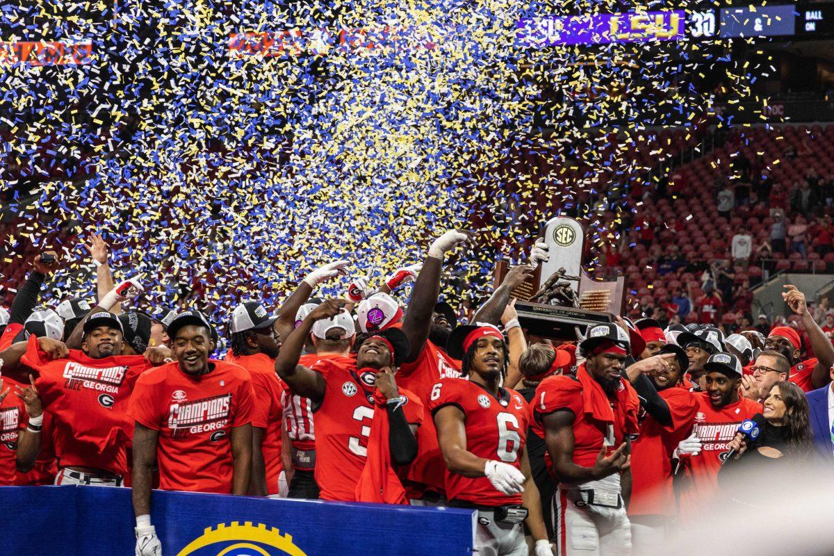 Georgia football players celebrate with the SEC Championship trophy Saturday, Dec. 3, 2022, after defeating LSU 30-50 at the Mercedes-Benz Stadium in Atlanta, Georgia.