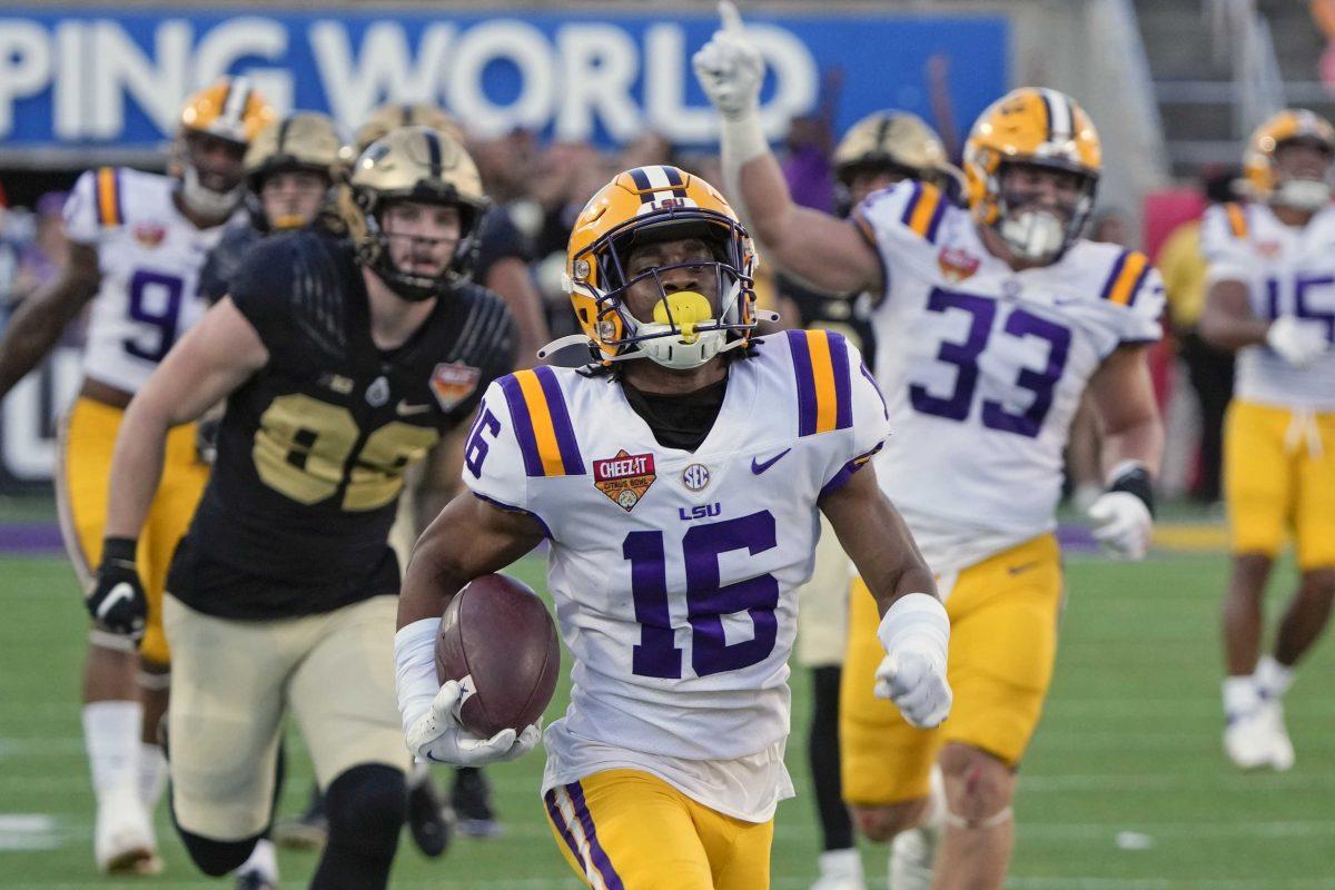 LSU cornerback Quad Wilson (16) returns a Purdue interception 99-yards as he gets past Purdue tight end Drew Biber, left, for a touchdown during the second half of the Citrus Bowl NCAA college football game Monday, Jan. 2, 2023, in Orlando, Fla. (AP Photo/John Raoux)