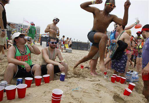 Ross House jumps over a beer pong game while celebrating spring break on the beach Thursday, March 17, 2016, at South Padre Island, Texas. (Nathan Lambrecht/The Monitor via AP)&#160;