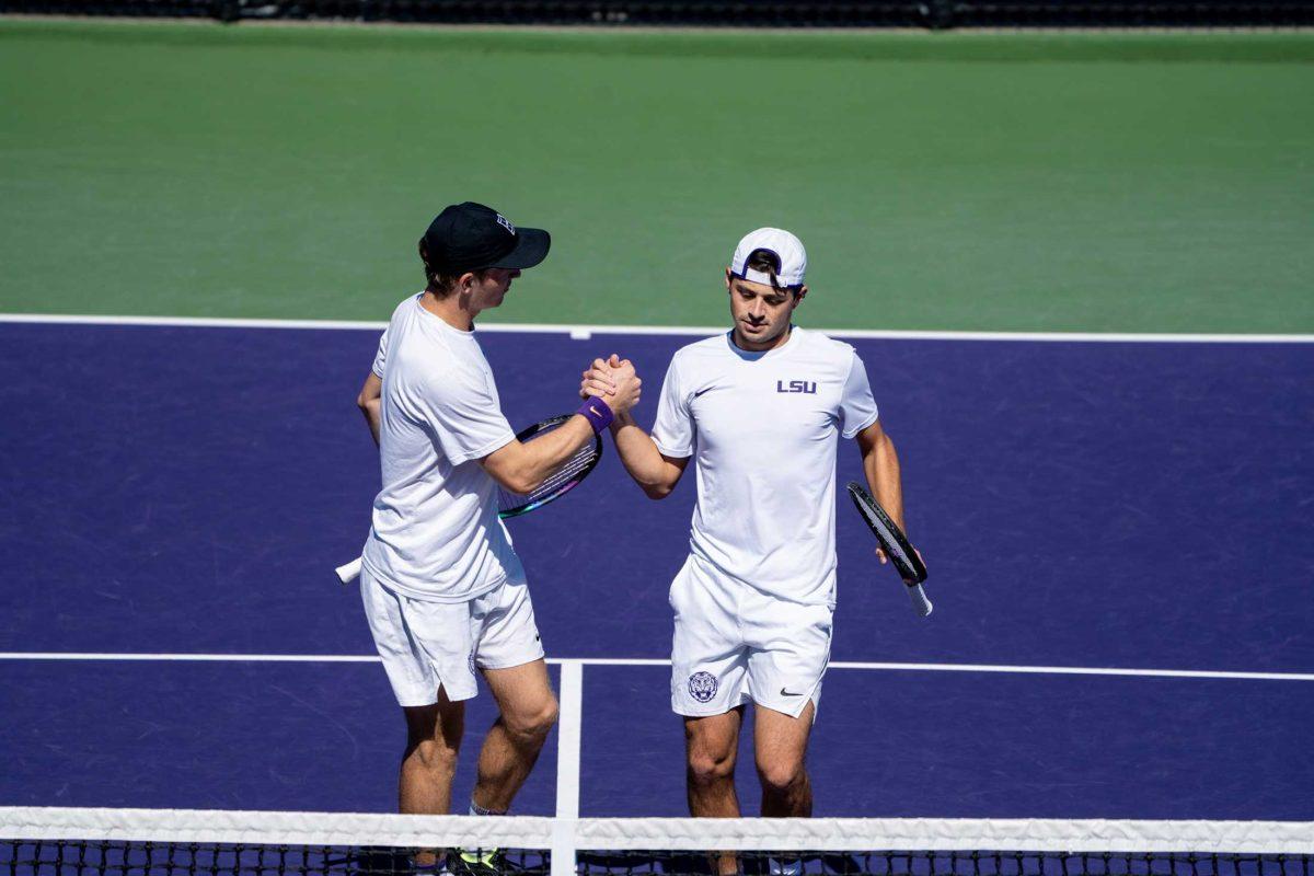 LSU men's tennis senior George Stoupe and junior Ronald Hohmann shake hands during their 6-4 doubles win against Lamar Sunday, Feb. 12, 2023, at the LSU tennis complex on Gourrier Avenue in Baton Rouge, La.