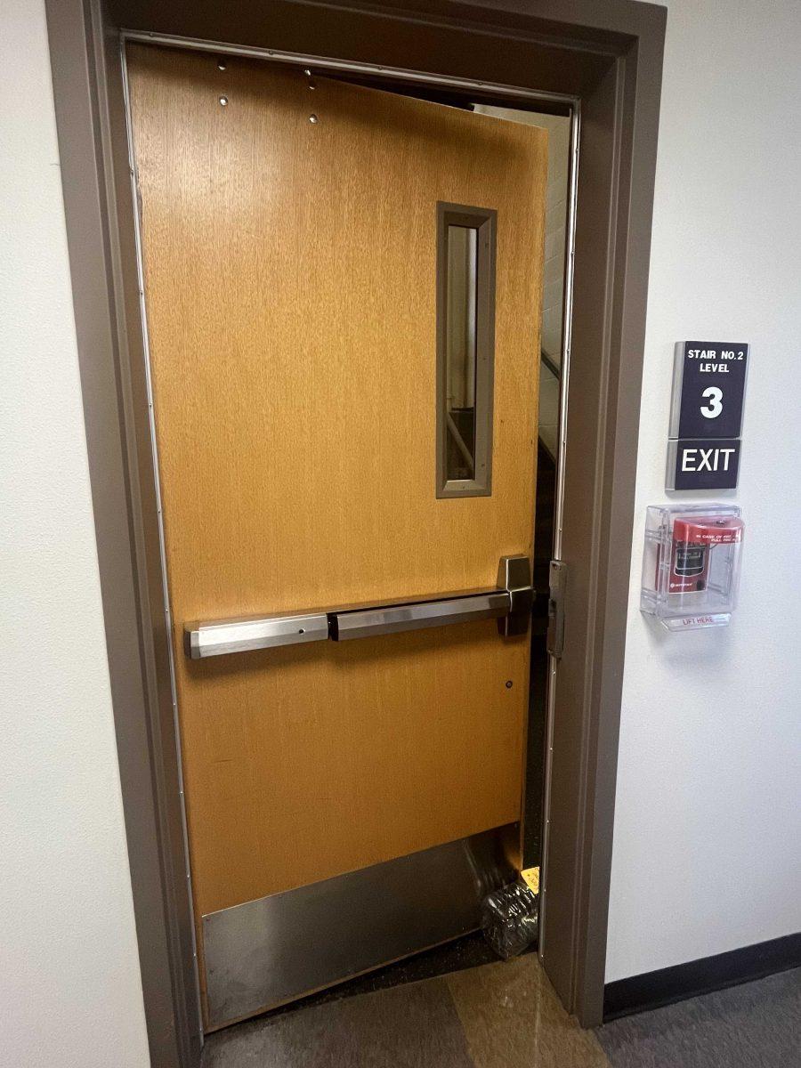 A door in South Hall is propped open by an empty plastic one gallon jug.