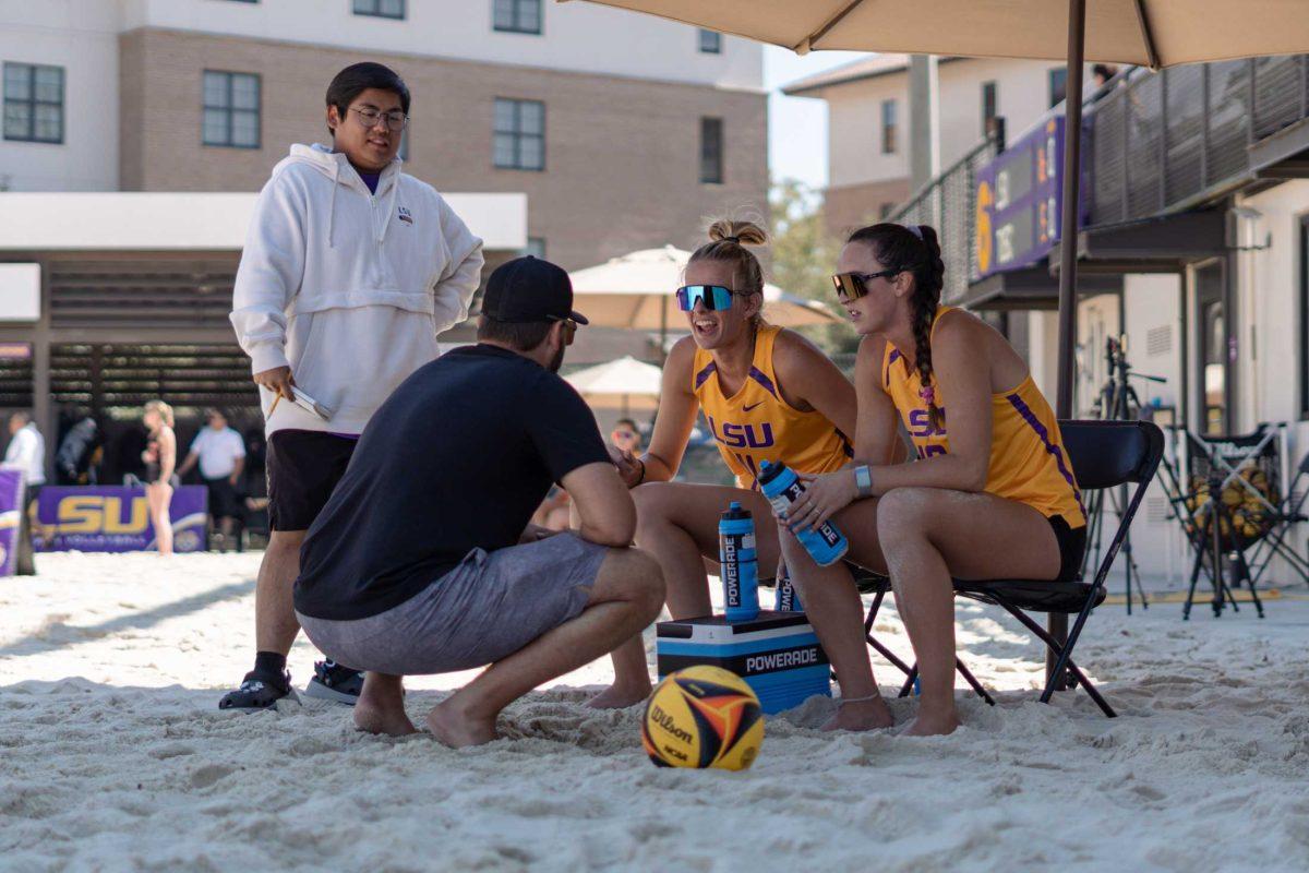 LSU beach volleyball senior Grace Seits (11) and sophomore Parker Bracken (10) talk with their coach on Sunday, March 5, 2023, during LSU&#8217;s 5-0 win against North Alabama at the Beach Volleyball Stadium on Cypress Drive in Baton Rouge, La.