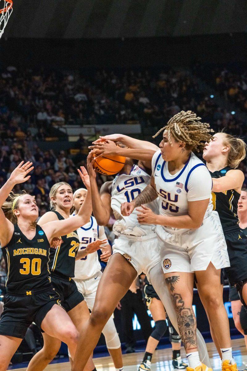 LSU women's basketball sophomore guard Kateri Poole (55) and forward Angel Reese (10) fight for the ball during their 66-42 win against Michigan in the second round of March Madness Sunday, March 19, 2023, at the Pete Maravich Assembly Center on N. Stadium Drive in Baton Rouge, La.