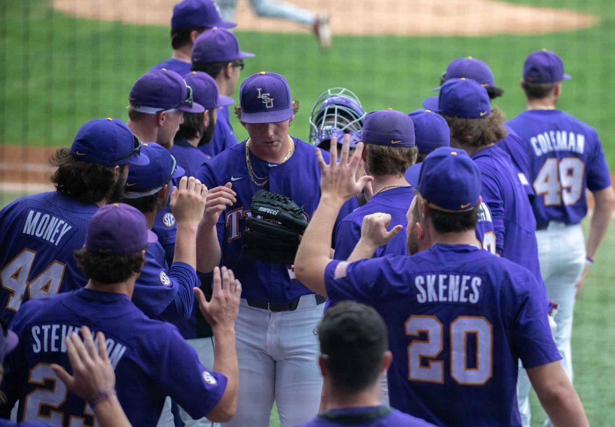 LSU baseball players high five LSU baseball freshman right-handed pitcher Chase Shores (34) on Friday, March 24, 2023, during LSU's 3-9 loss against Arkansas in Alex Box Stadium in Baton Rouge, La.