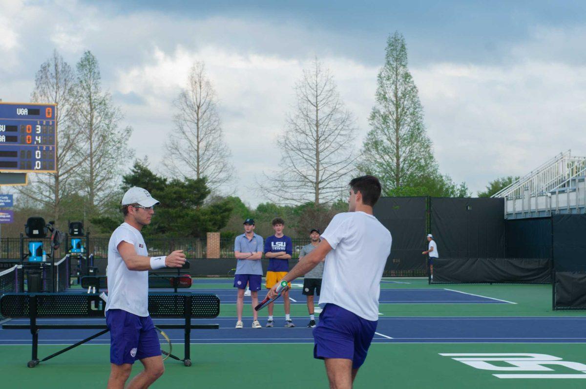 LSU men's tennis senior Stefan Latinovic and LSU men's tennis graduate student Nick Watson fist bump after scoring a point in a doubles competition during LSU's 5-2 loss against UGA Friday, March 24, 2023 at the LSU Tennis Complex in Baton Rouge.