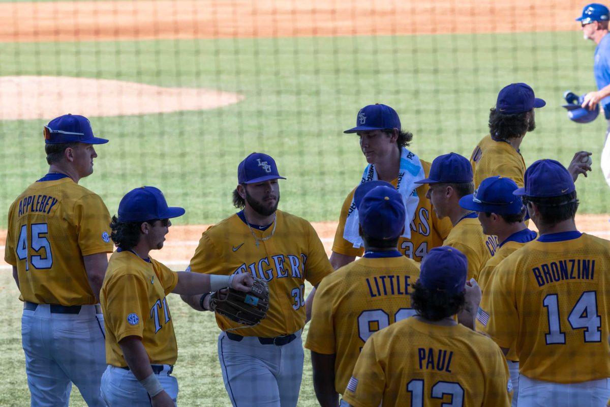 LSU baseball players gather Sunday, March 5, 2023, outside the dugout during the middle of the inning amidst LSU baseball's 13-0 victory over Central Connecticut State at Alex Box Stadium in Baton Rouge, La.