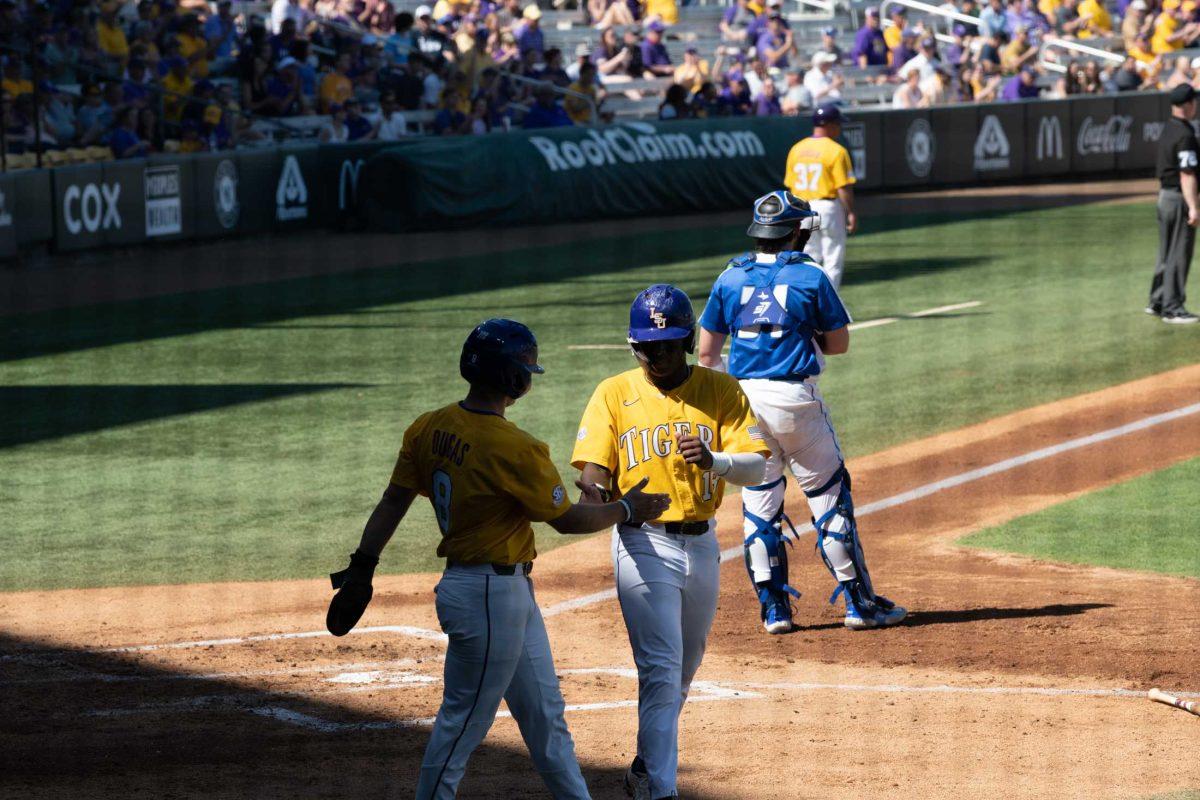 LSU baseball junior first baseman Tre&#8217; Morgan (18) high fives graduate student infielder/outfielder Gavin Dugas (8) Sunday, March 5, 2023, after they both score during LSU baseball's 13-0 victory over Central Connecticut State at Alex Box Stadium in Baton Rouge, La.