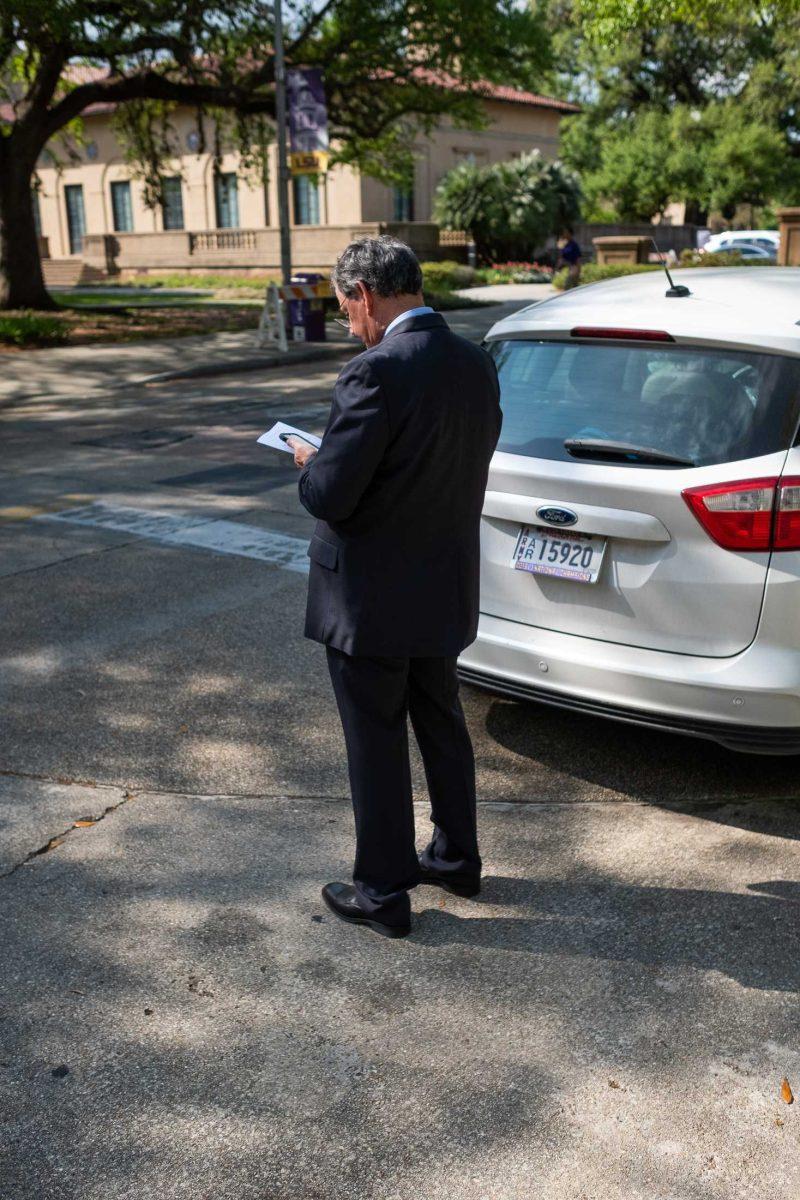 A man on his phone stops short before crossing Tower Drive on March 23, 2023, on LSU's campus.