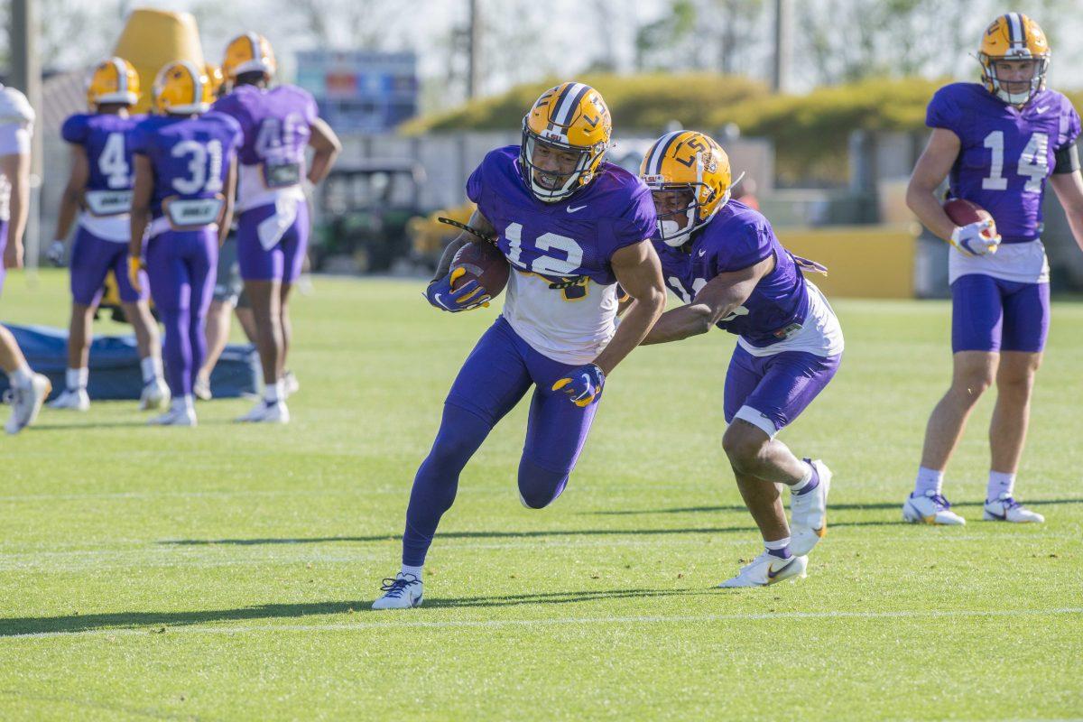 LSU football defensive back Greg Brooks Jr. (12) runs while being tackled Thursday, April 7, 2022, during LSU&#8217;s spring practice in Baton Rouge, Louisiana.