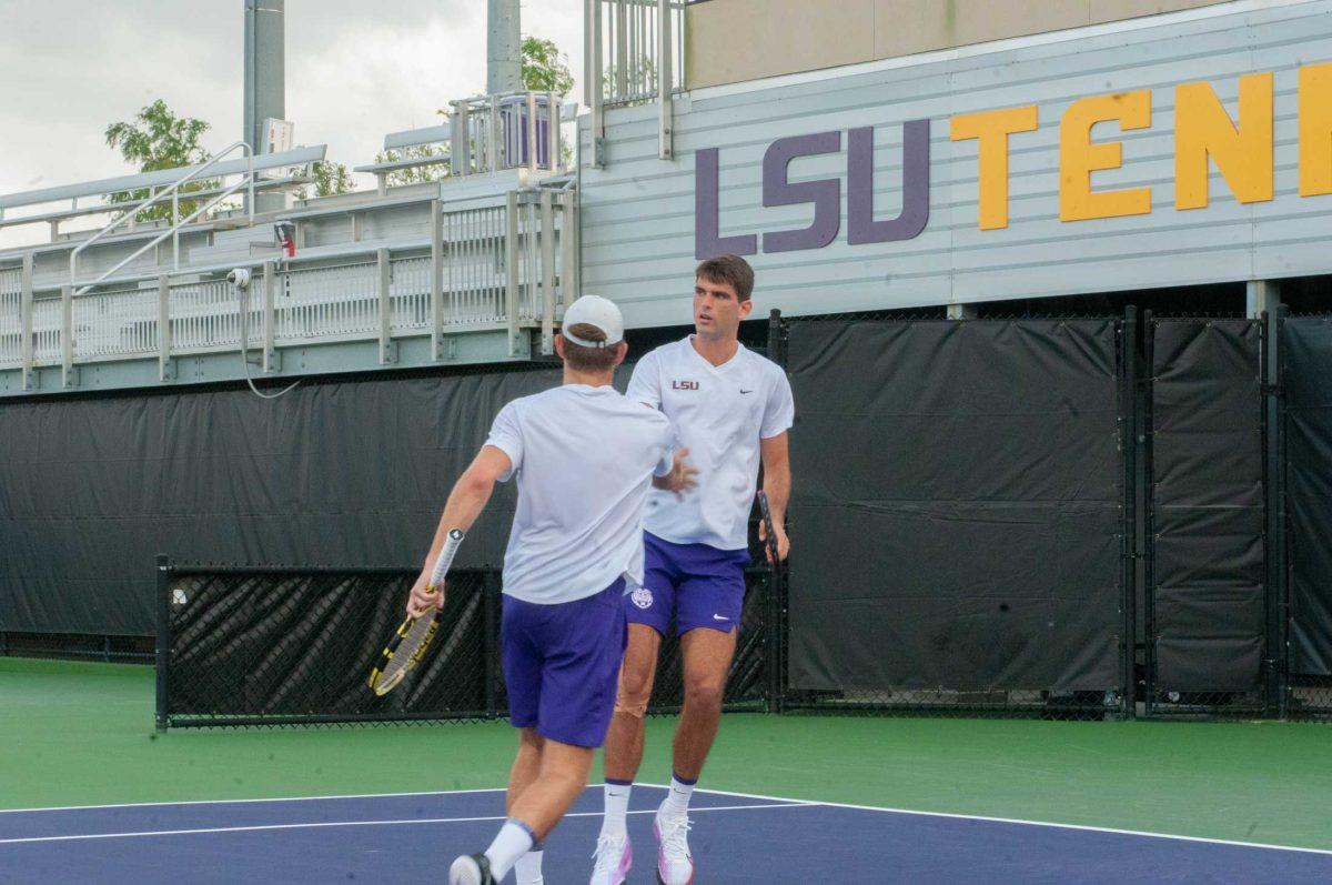 LSU men's tennis senior Stefan Latinovic and LSU men's tennis graduate student Nick Watson fist bump after scoring a point in a doubles competition during LSU's 5-2 loss against UGA Friday, March 24, 2023 at the LSU Tennis Complex in Baton Rouge.