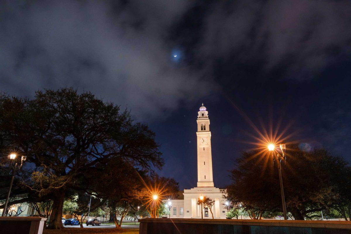 The moon shines above Memorial Tower on Thursday, Feb. 23, 2023, on Tower Drive in Baton Rouge, La.