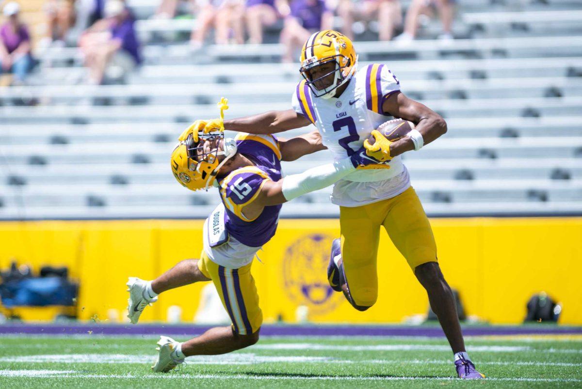 LSU football senior wide receiver Kyren Lacy (2) stiff arms his opponent, LSU football redshirt freshman safety Sage Ryan (15), on Saturday, April 22, 2023, during LSU&#8217;s 32-32 tie during the spring game in Tiger Stadium in Baton Rouge, La.