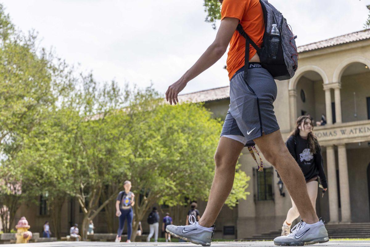 A student walks across the Quad in front of Atkinson Hall Monday, March 27, 2023, on LSU's campus.