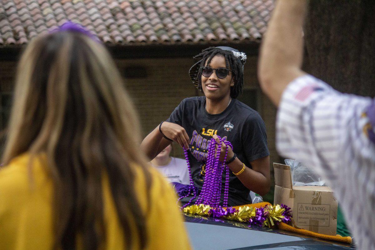 LSU women's basketball freshman forward Sa'Myah Smith prepares to throw a bead at a lucky fan Wednesday, April 5, 2023, during the women's basketball team parade through LSU's campus.