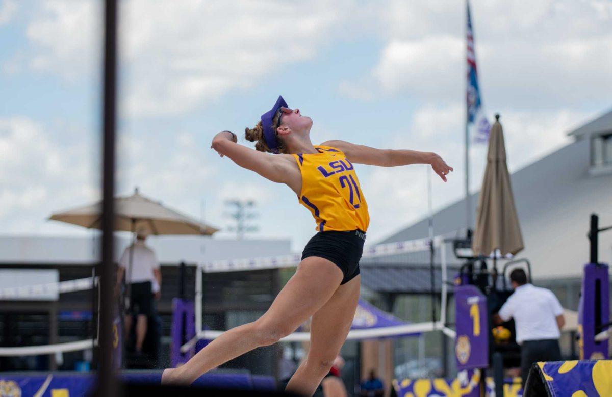 LSU beach volleyball sophomore Cassidy Chambers (21) leaps to serve the ball on Friday, April 14, 2023, during LSU&#8217;s 5-0 victory against Nicholls in Baton Rouge, La.