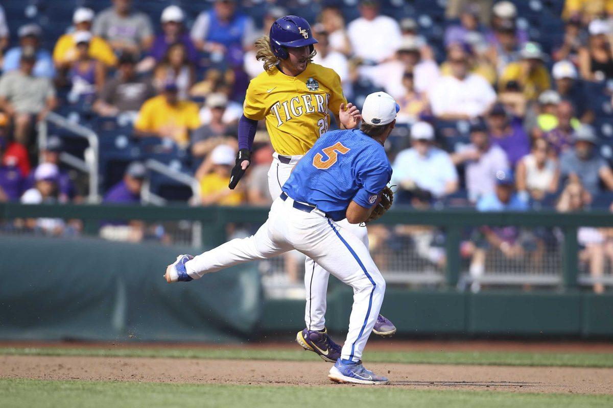 Florida infielder Colby Halter (5) tags out LSU's Paxton Kling (28) during the eighth inning of Game 2 of the NCAA College World Series baseball finals in Omaha, Neb., Sunday, June 25, 2023. (AP Photo/John Peterson)