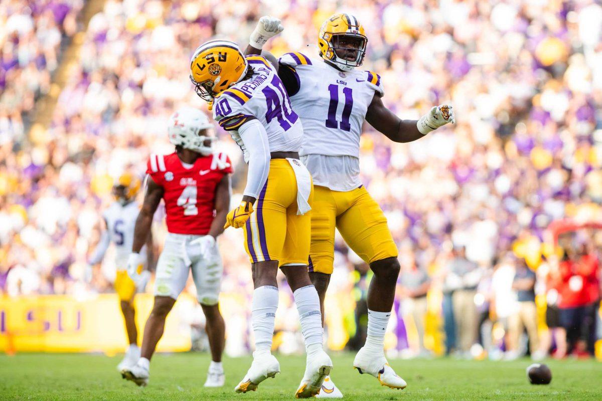 LSU football freshman linebacker Harold Perkins Jr. (40) and fifth-year defensive end Ali Gaye (11) celebrate after a defensive stop Saturday, Oct. 22, 2022, during LSU&#8217;s 45-20 win against Ole Miss at Tiger Stadium in Baton Rouge, La.