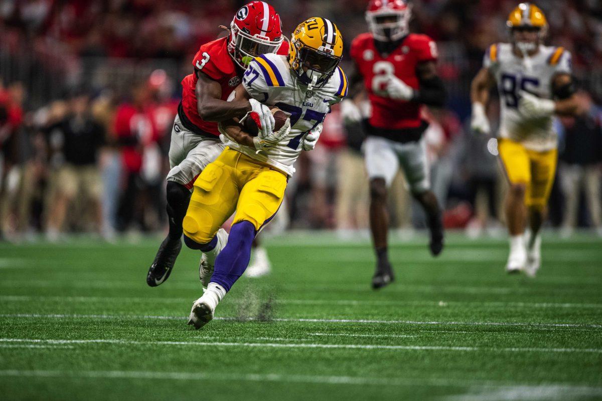 LSU football junior running back Josh Williams (27) pushes off Georgia defensive back Kamari Lassiter (3) Saturday, Dec. 3, 2022, during LSU's 30-50 defeat to Georgia at the Southeastern Conference Championship in the Mercedes-Benz Stadium in Atlanta, Georgia.