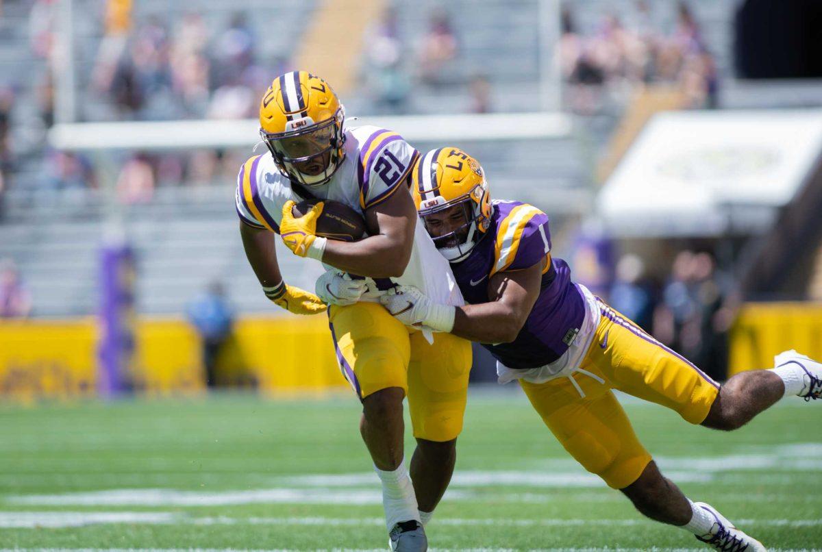 LSU football senior running back Noah Cain (21) attempts to avoid his opponent, LSU football junior linebacker Omar Speights (1), on Saturday, April 22, 2023, during LSU&#8217;s 32-32 tie during the spring game in Tiger Stadium in Baton Rouge, La.